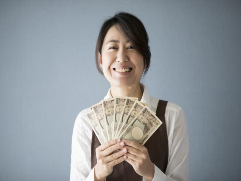 笑顔で紙幣を持つ女性